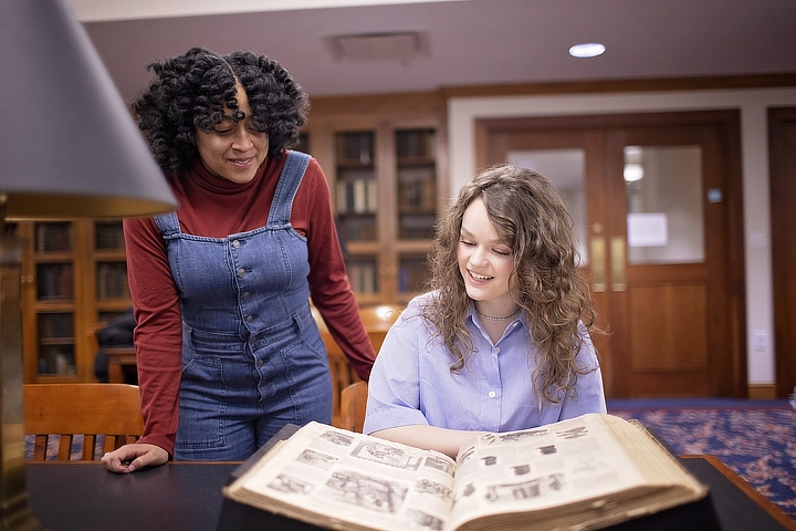 two history students looking at book