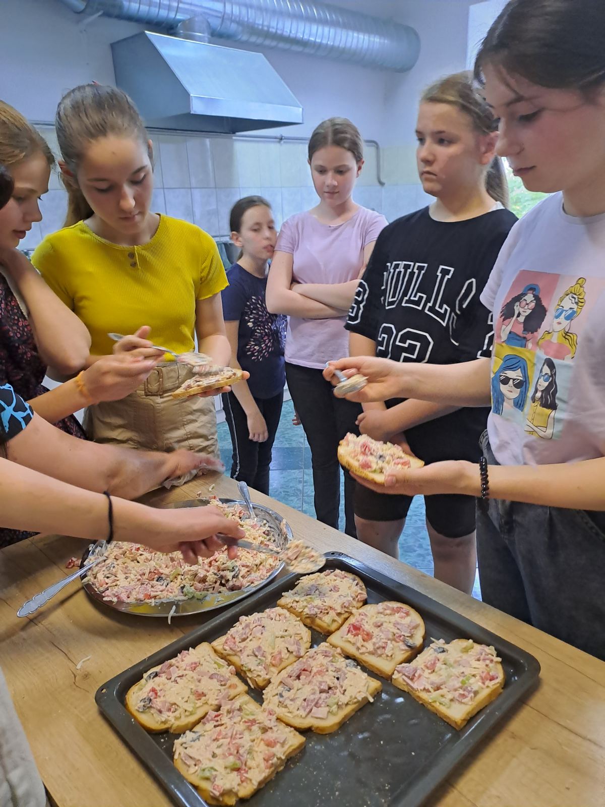 young women making pizzas