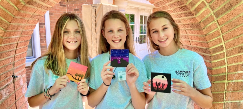 three girls showing small paintings