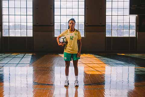 female student in gym with volleyball