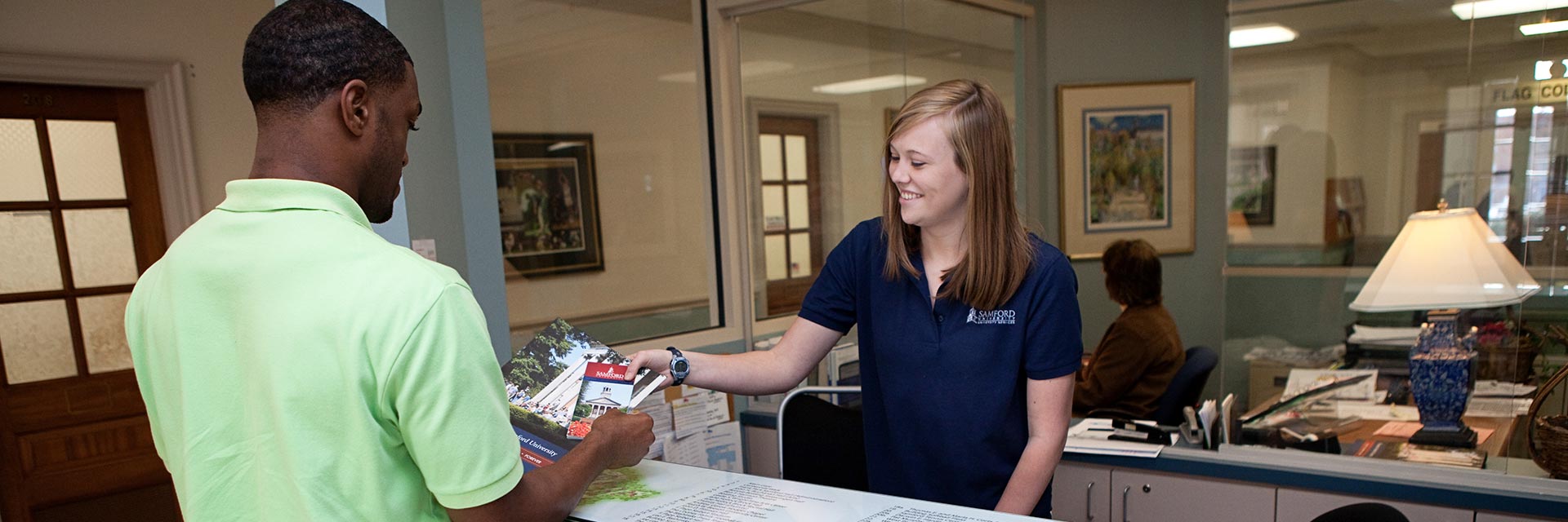 female student worker helping male student at HUB