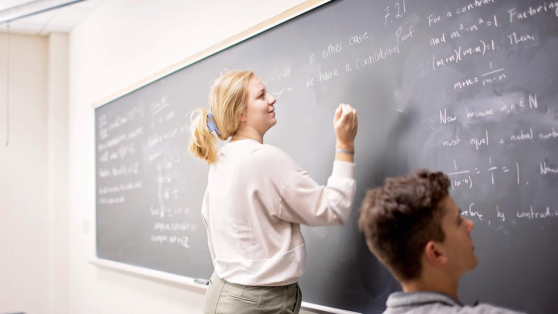 students writting on chalkboard