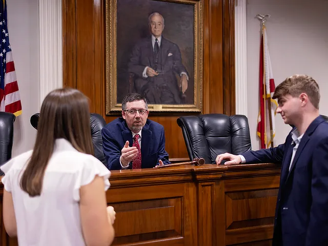 professor with two students in courtroom