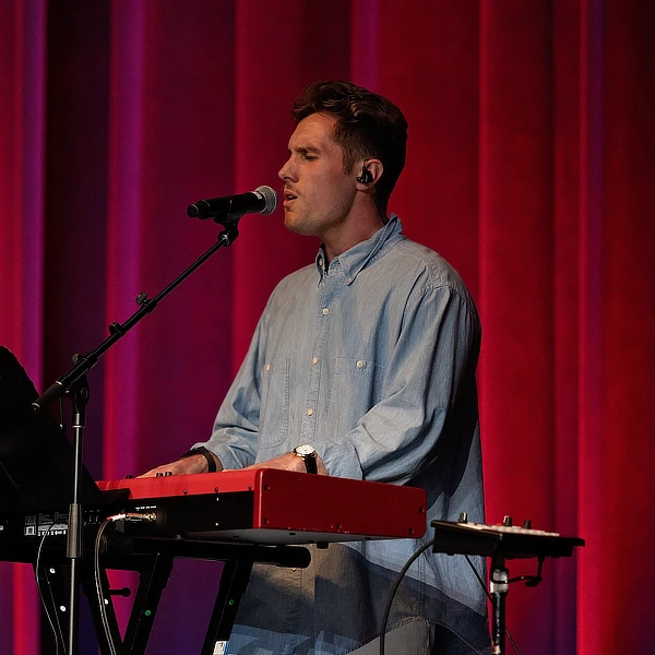 male student singing and playing music