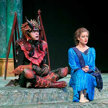 Male and female performers in costume on stage