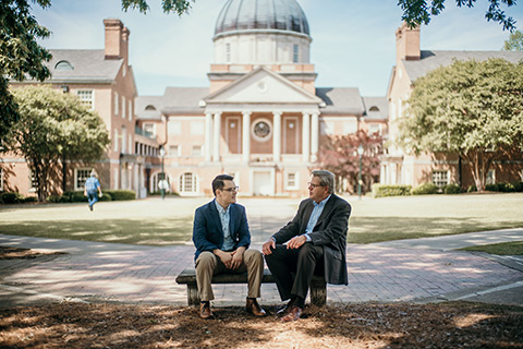 Photo of professors sitting outside.