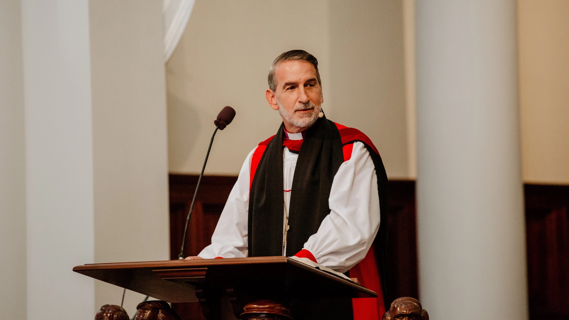 man in anglican garb preaching