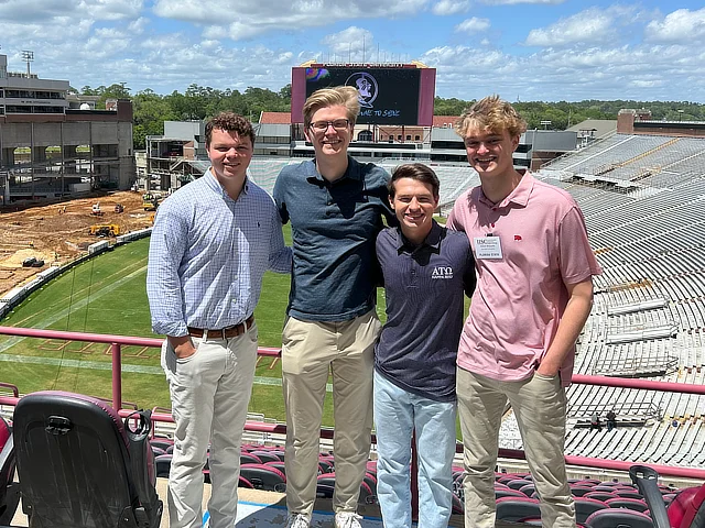 four student standing in fsu stadium