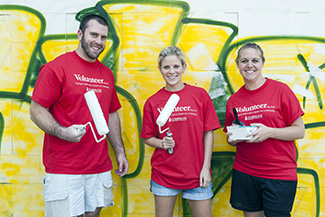 students holding paintbrushes at the First Year Service Project