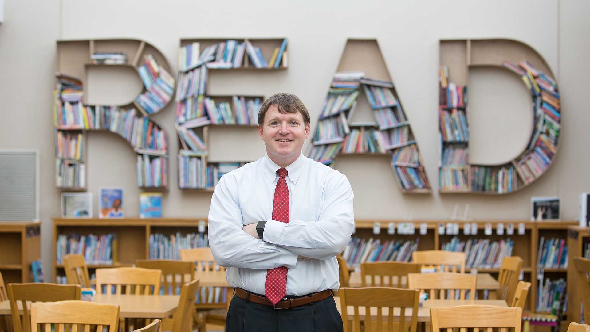 male teacher in school library