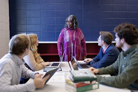 female teacher with students at a table