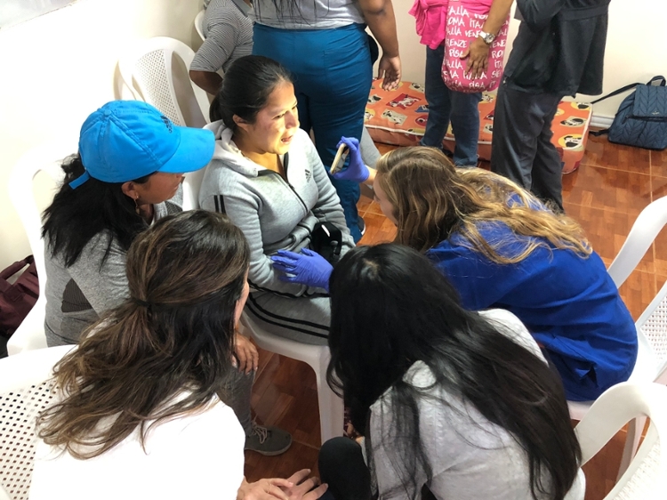 Students performing a health check in Ecuador