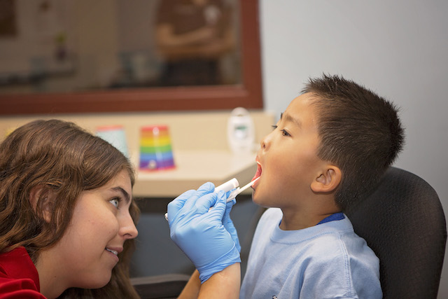 student examining child's throat