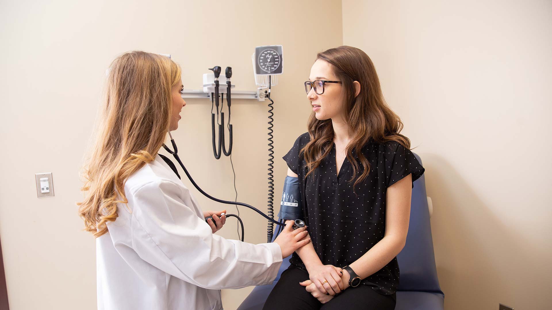 woman in white coat examining patient