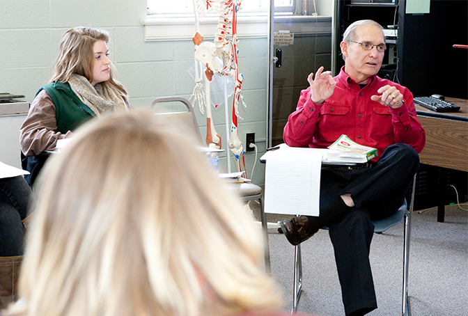 photo of professor holding a discussion with students in class