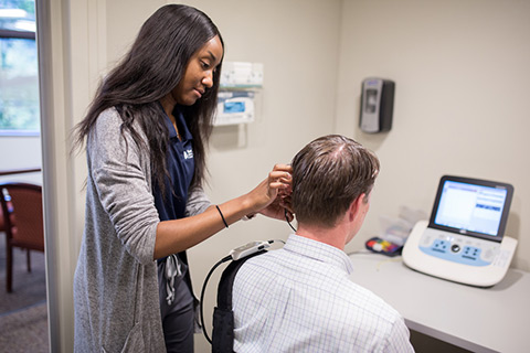 Professor in Audiology Booth with students