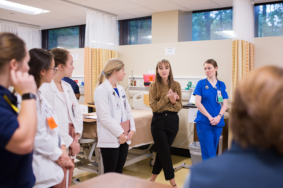 Students participate in the simulation's grand rounds.