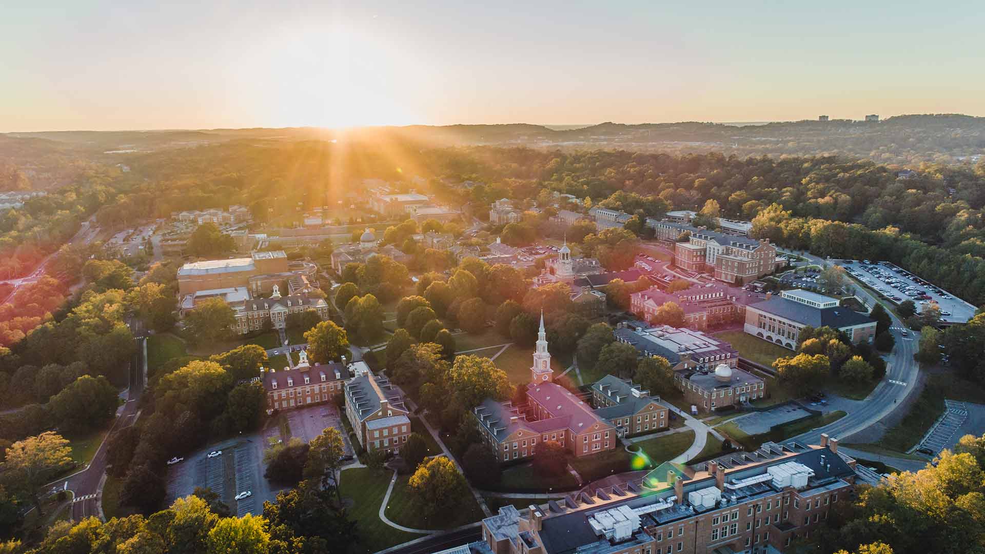 drone view of campus toward setting sun