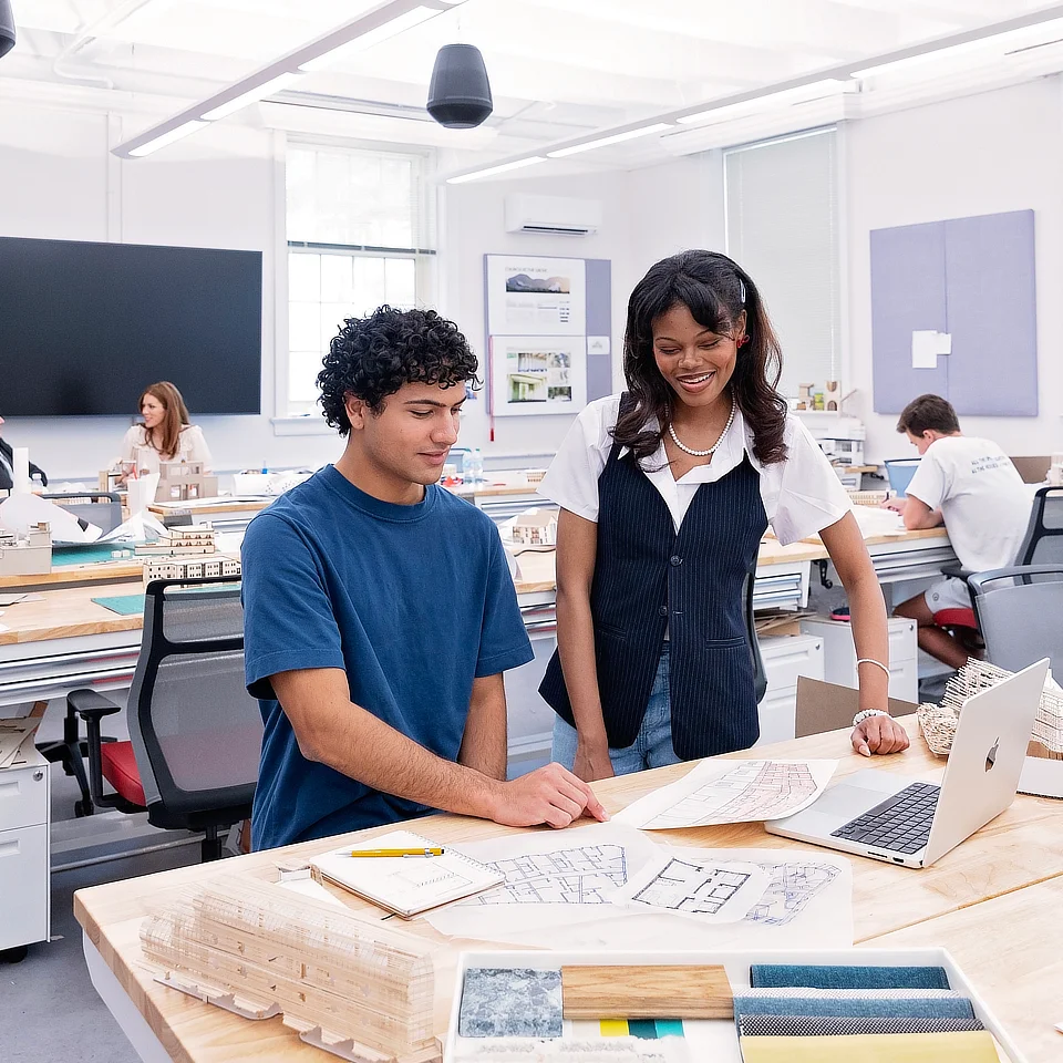 two students working on a laptop