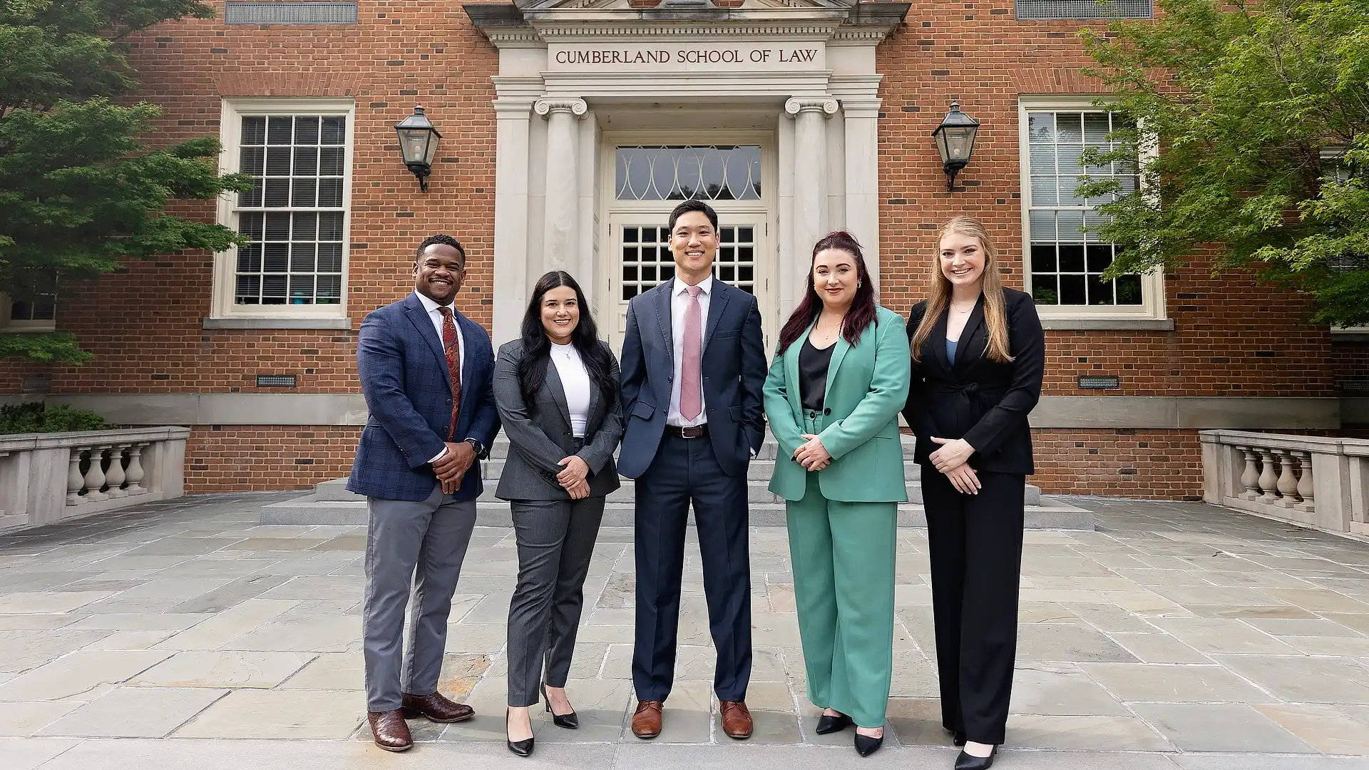 five law students standing outside of the law school