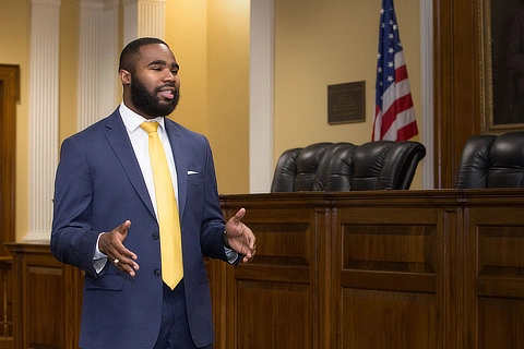 male law student standing in courtroom