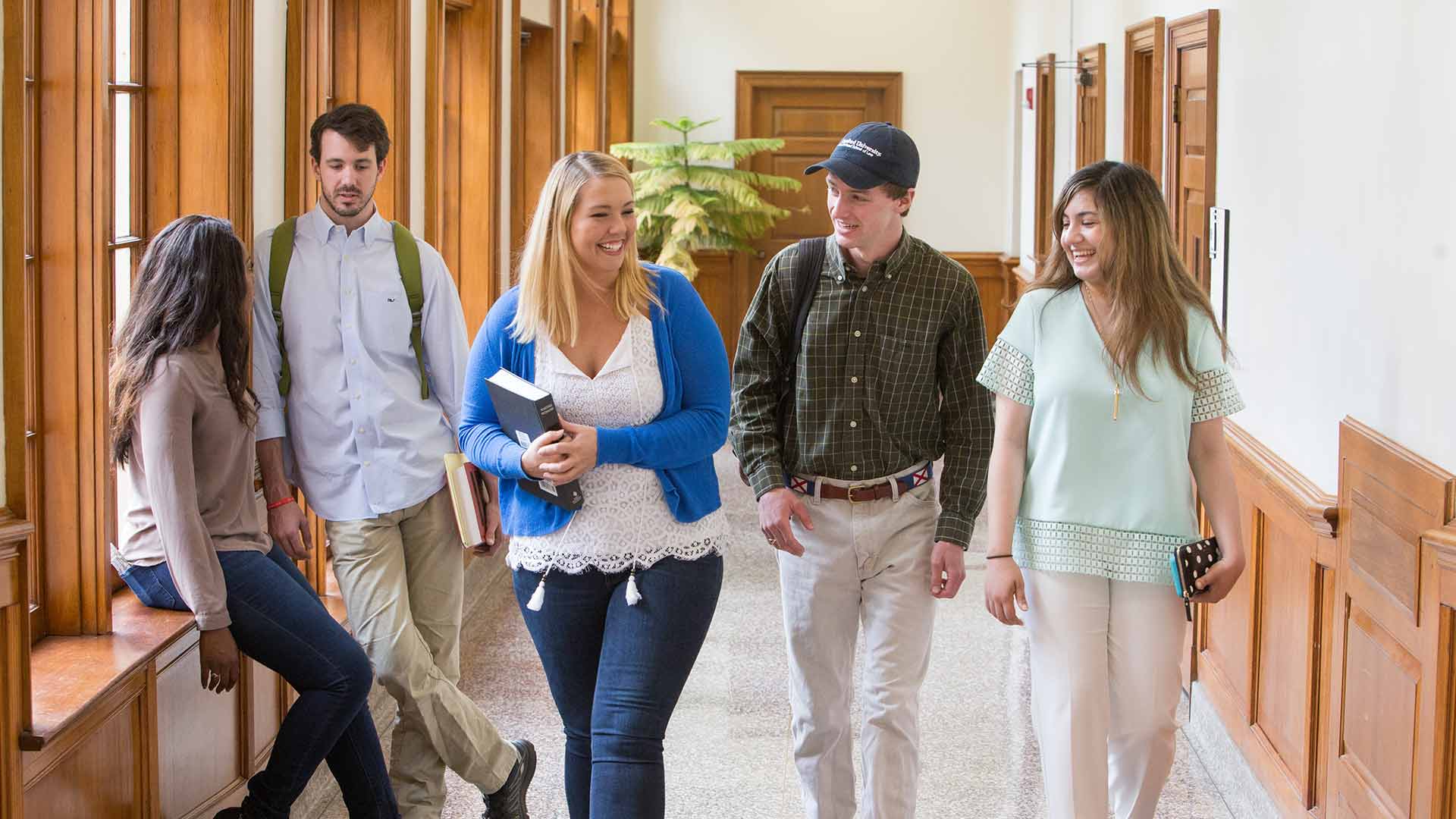 female and male students walking in the hall