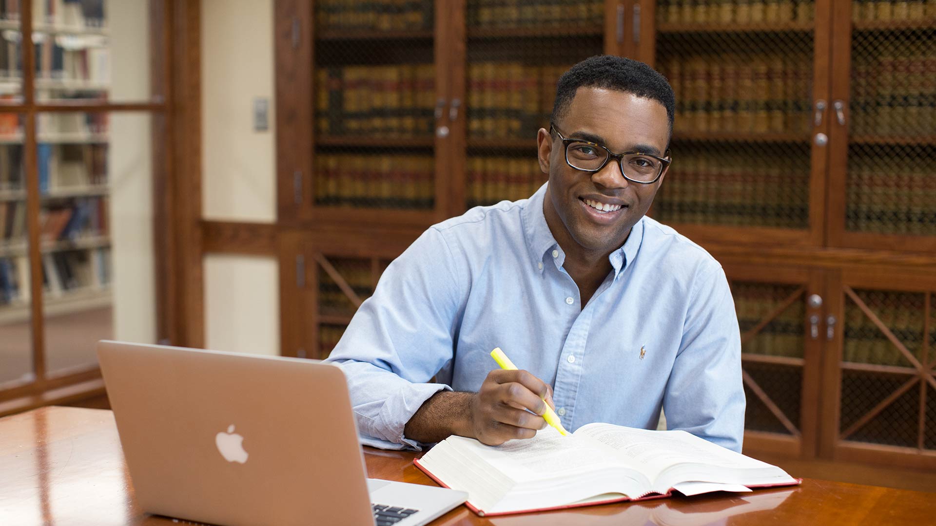 Male student highlighting textbook