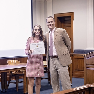 law dean and a student with an award