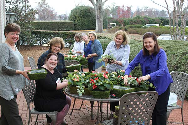 Seven women making flower centerpieces