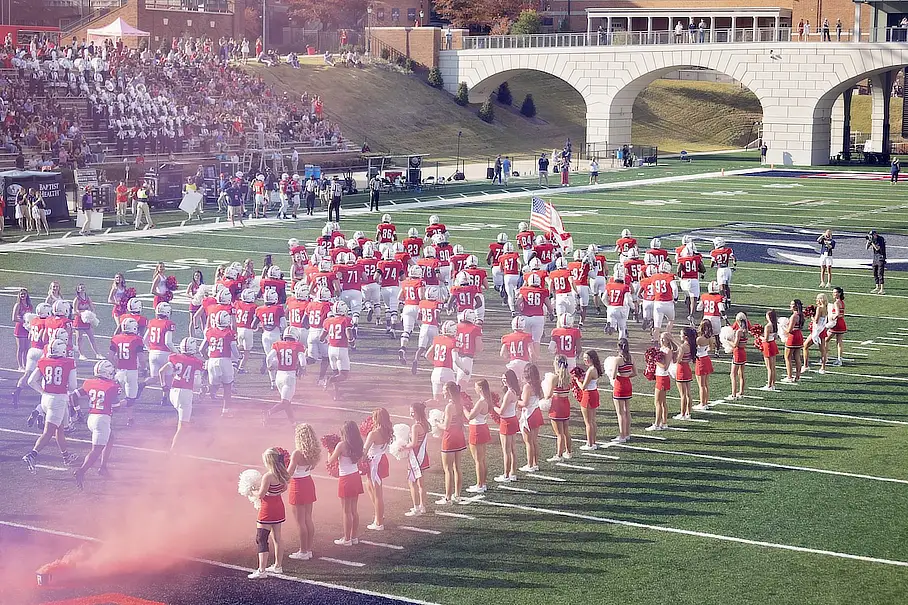 Samford football team runs takes the field