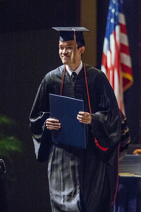 male graduate holding diploma