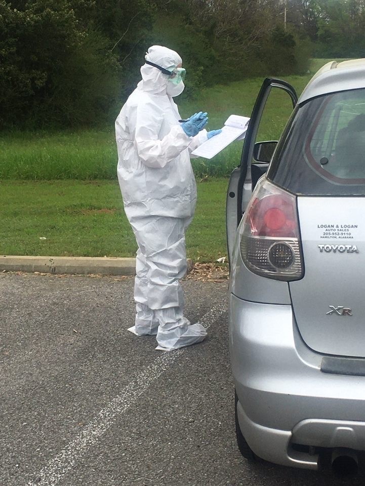 Shanahan giving a COVID-19 test at a patient's car