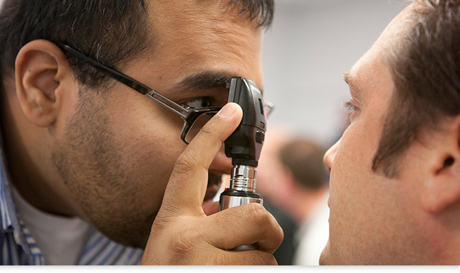 nurse checking eyes of patient