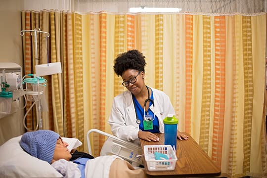 nurse helping patient in acute care simulation