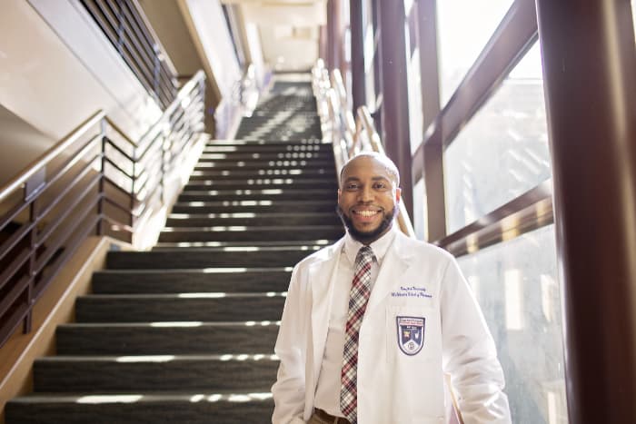 smiling pharmacy student by stairs