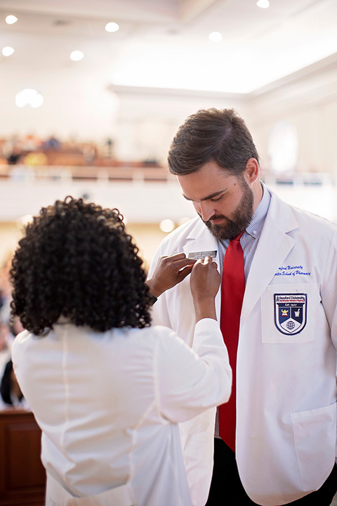 pharmacy pinning student on stage