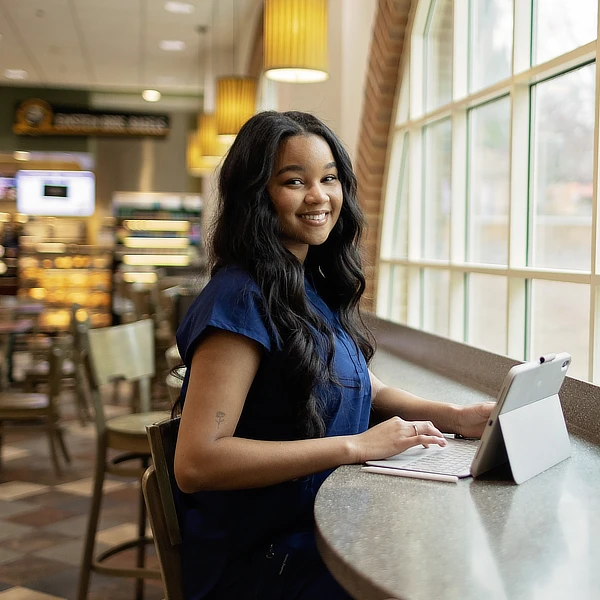 female online nursing student at a coffee shop