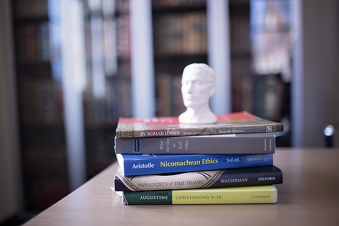 stack of books with bust