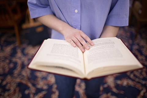 student holding open book