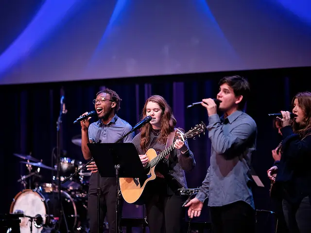 four young people singing