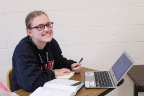 smiling female student with laptop