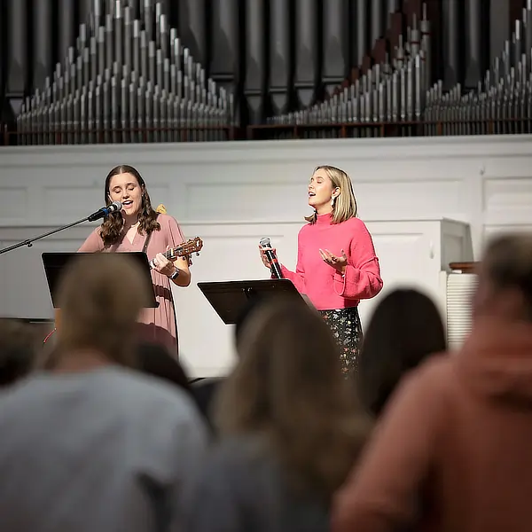 two women singing in worship