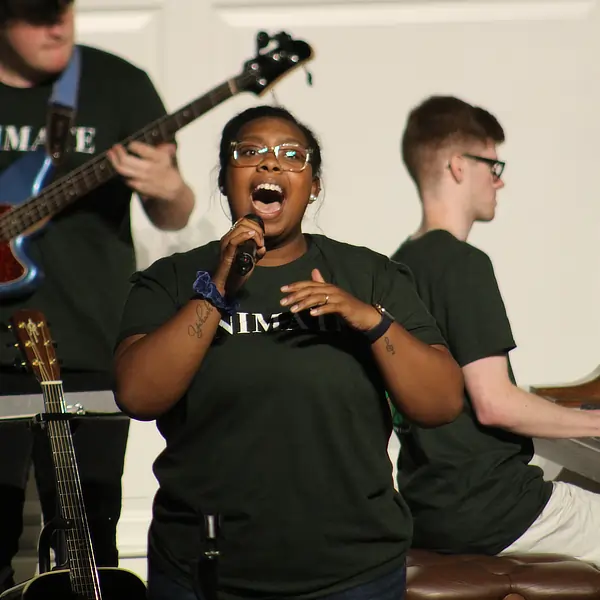 young woman singing with band